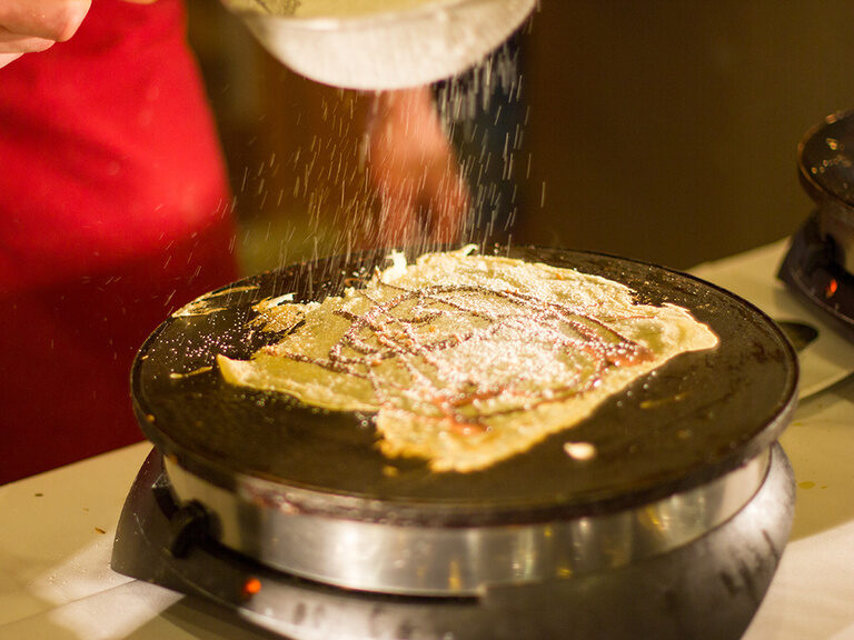 Crêpes-Station mit frischen Crêpes und verschiedenen Toppings, die live zubereitet werden.