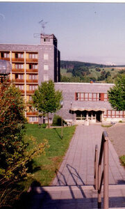 Chronikbild des Hotels mit altem Spielplatz, altem Eingang und unrestaurierten Balkonen