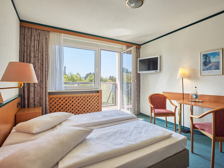 Klassisches Doppelzimmer mit Balkon im Aparthotel Am Rennsteig. Perfekt für den Thüringen Urlaub mit Kindern oder zu zweit, inklusive Halbpension und Blick in den Thüringer Wald.