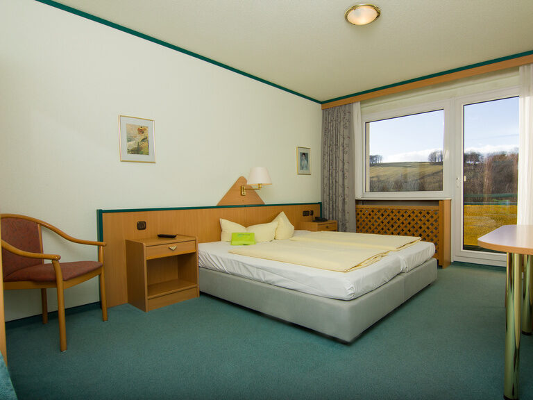 Gemütliches 1-Raum Einzelzimmer (Doppelzimmer zur Einzelnutzung) mit Balkon und Blick in die Thüringer Natur. Preise inklusive Halbpension für Erwachsene.