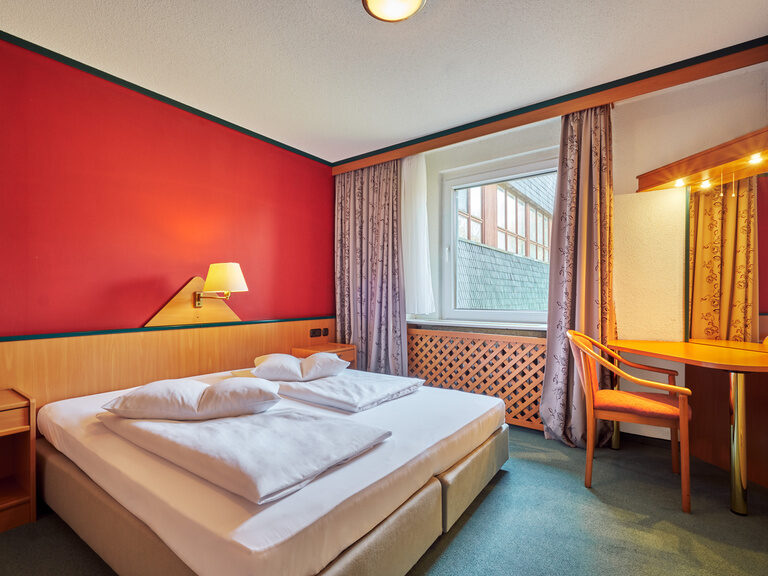 Elternschlafzimmer in der Suite – Thüringen Urlaub mit Kindern Komfortables Eltern-Schlafzimmer in der größten Suite des Familienhotels Am Rennsteig. Inklusive Balkon und Blick in die Thüringer Natur für Ihren Thüringen Urlaub mit Kindern.