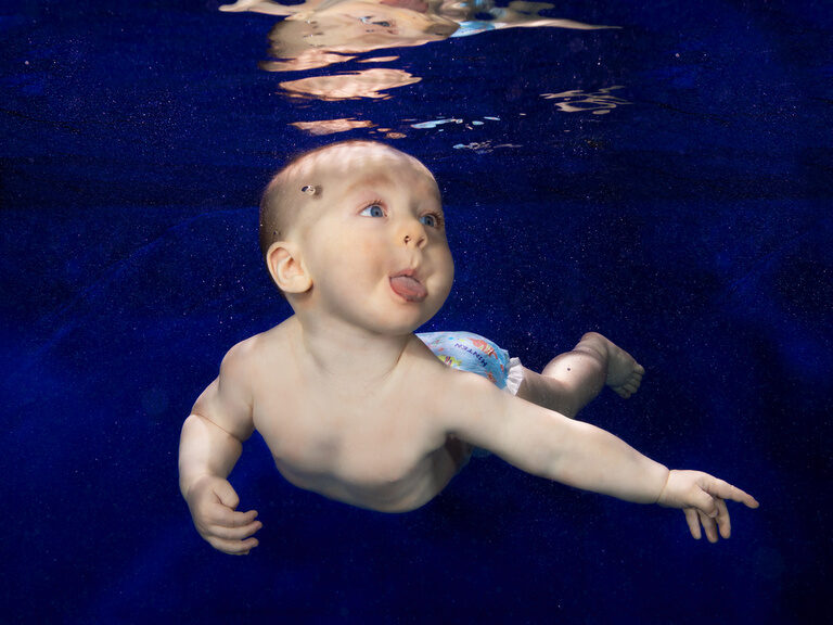 Ein Kleinkind erlebt seine ersten Unterwassererfahrungen im Kinderinnenpool des Familienhotels.