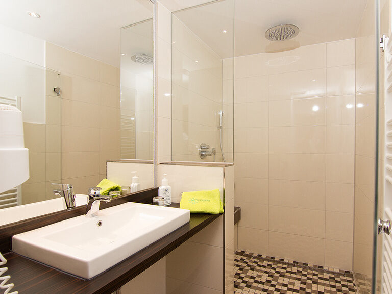 Helles und modernes Badezimmer im renovierten Superior Zimmer, speziell für Familien konzipiert, für einen stressfreien Start in den Tag.